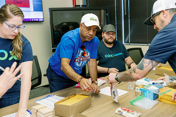 Volunteers from Cox Communications help each other assemble STEM for All Kits. (Photography by Katherine Nicole)