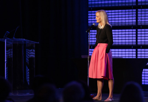 A storyteller pauses mid-story on the illuminated stage.
