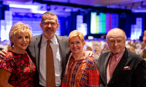 Four guests smiling together at the gala reception.