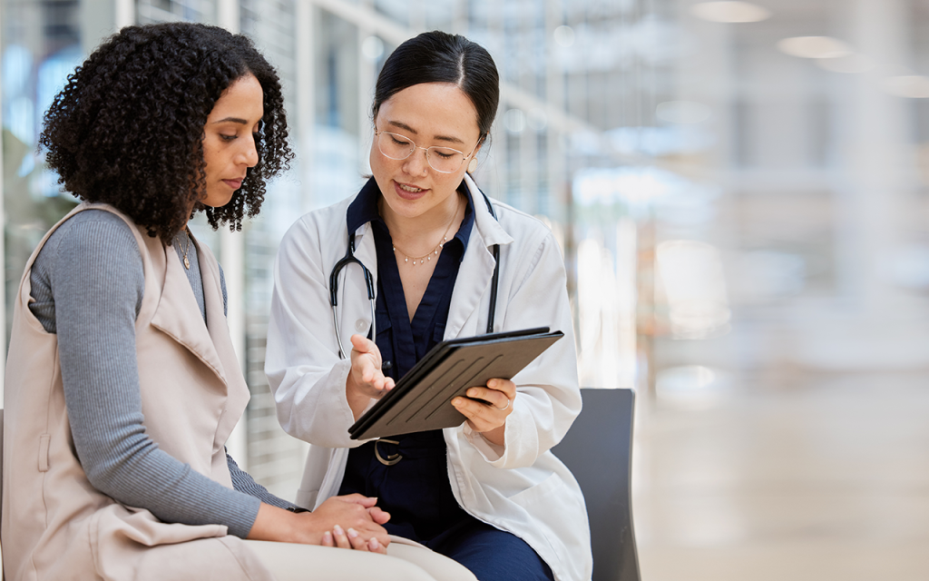 Clinician and patient reviewing a tablet during a consultation