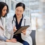 Clinician and patient reviewing a tablet during a consultation