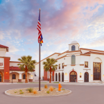 Exterior of the Hilltop Theatre and Concert Hall at dusk with an American flag